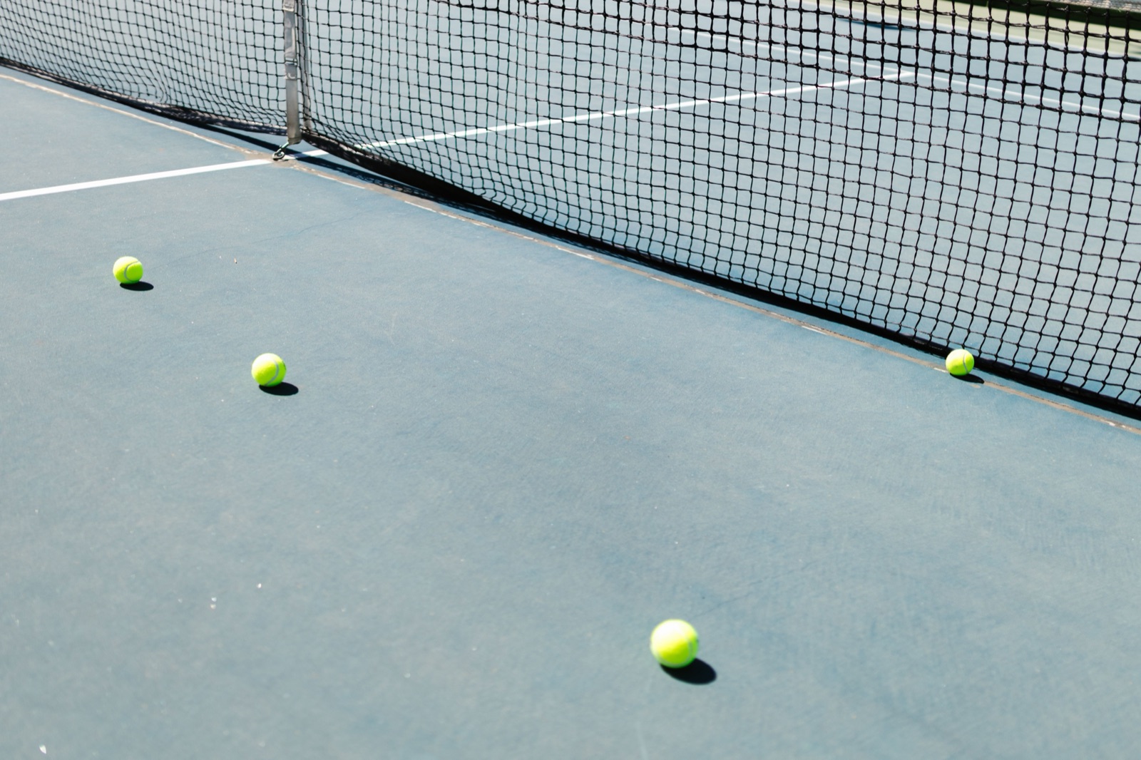 Two glass-walled padel courts with players mid-rally