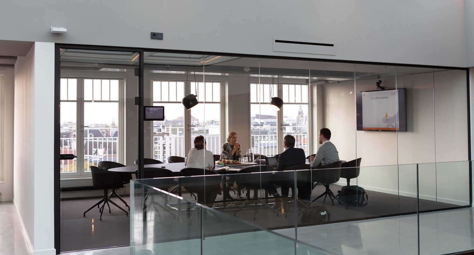 Bright modern office with a glass-walled meeting room and bookable hot desks